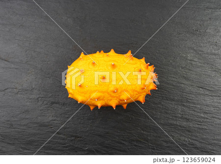 Kiwano on black plate, jelly melon, cucumis metuliferus ripe fruit, orange spiked horned melon Kiwano on black plate, jelly melon, cucumis metuliferus ripe fruit, orange spiked horned melon 123659024