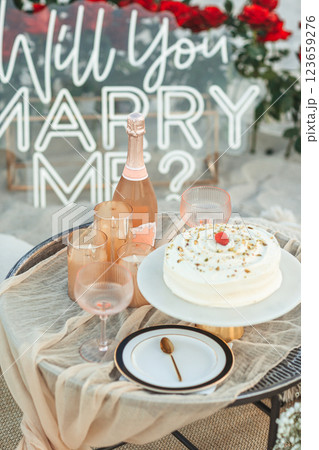 Beach Proposal Decor with Will You Marry Me Sign, Flowers and Cozy Area. Will You Marry Me Proposal 123659276