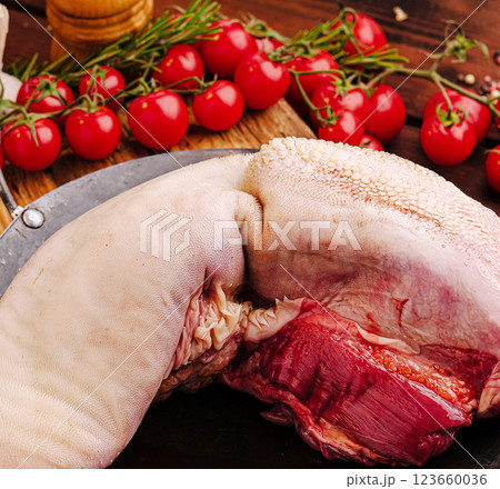 Fresh meats and vibrant tomatoes prepared on a rustic wooden table Fresh meats and vibrant tomatoes prepared on a rustic wooden table 123660036