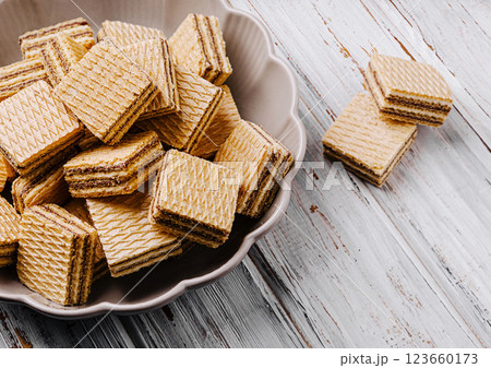 Delicious layered wafers arranged in a bowl on a wooden table Delicious layered wafers arranged in a bowl on a wooden table 123660173