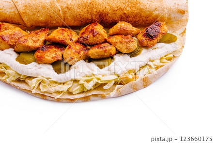Grilled chicken wrap with creamy sauce and pickles on flatbread Grilled chicken wrap with creamy sauce and pickles on flatbread 123660175