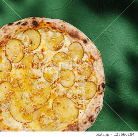 Unique potato pizza on a green surface with toppings 123660184