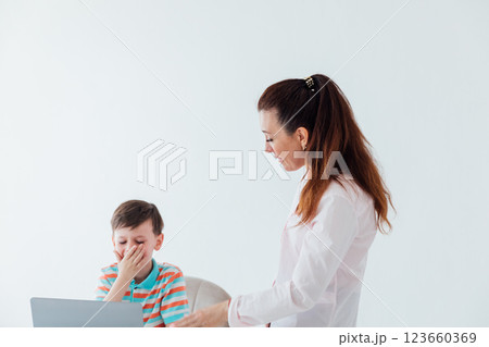 Female teacher helping boy on laptop to play Female teacher helping boy on laptop to play 123660369