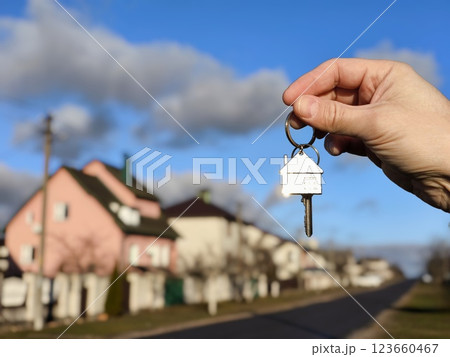 The concept of buying an apartment. Man holds the keys to the house in his hands against the backdrop of residential buildings. Concept for buying and renting apartments The concept of buying an apartment. Man holds the keys to the house in his hands against the backdrop of residential buildings. Concept for buying and renting apartments 123660467