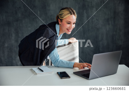 woman blonde at desk with laptop in office online woman blonde at desk with laptop in office online 123660681