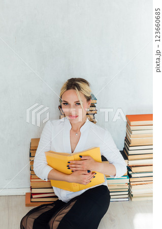 woman teacher and piles of university educational books 123660685