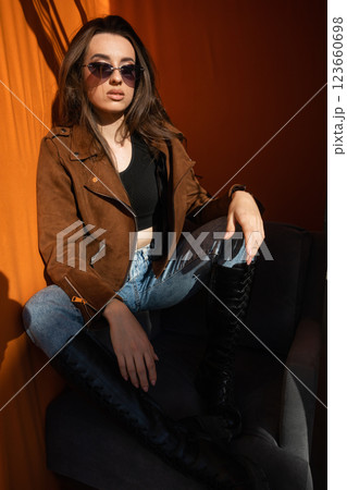 Beautiful slim fashionable woman in sunglasses sitting in chair 123660698