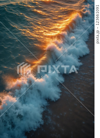 an impressive seascape view from above, a large and beautiful ocean wave on the beach, at sunset, sunlight and wind breaking through the crest of the wave, beautiful nature as a background 123661091