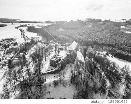 Pecka medieval castle stands majestic in a winter landscape, surrounded by snow-covered trees and hills. The scene captures the tranquility and charm of Czechia during wintertime. 123661435