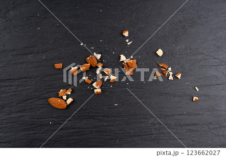 Crushed almonds, nut pieces, sliced scattered almond seeds and cut kernels collection on black background Crushed almonds, nut pieces, sliced scattered almond seeds and cut kernels collection on black background 123662027