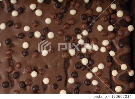 Chocolate brownie cake texture background sprinkled with white and dark balls, brounie banner 123662034