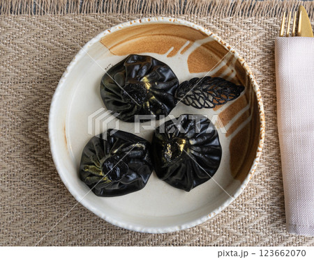 Black khinkali, Georgian seafood chinkali, spicy dumplings with minced meat also called dimsum Black khinkali, Georgian seafood chinkali, spicy dumplings with minced meat also called dimsum 123662070