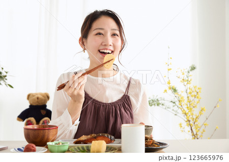 朝食にスマートフォンを見る女性 123665976