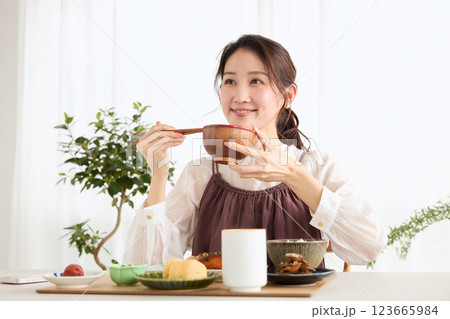 朝食にスマートフォンを見る女性 朝食にスマートフォンを見る女性 123665984
