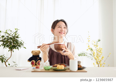 朝食にスマートフォンを見る女性 123665987