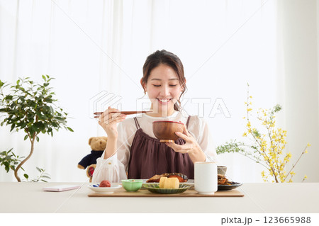 朝食にスマートフォンを見る女性 朝食にスマートフォンを見る女性 123665988