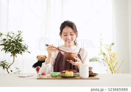 朝食にスマートフォンを見る女性 朝食にスマートフォンを見る女性 123665989