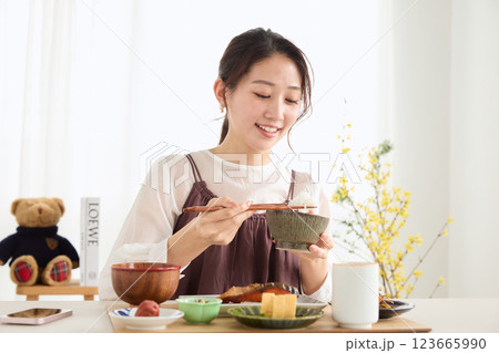 朝食にスマートフォンを見る女性 123665990