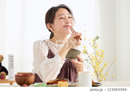 朝食にスマートフォンを見る女性 朝食にスマートフォンを見る女性 123665994