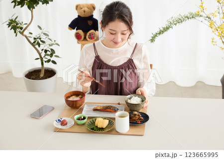 朝食にスマートフォンを見る女性 朝食にスマートフォンを見る女性 123665995