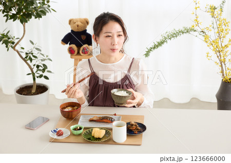 朝食にスマートフォンを見る女性 123666000