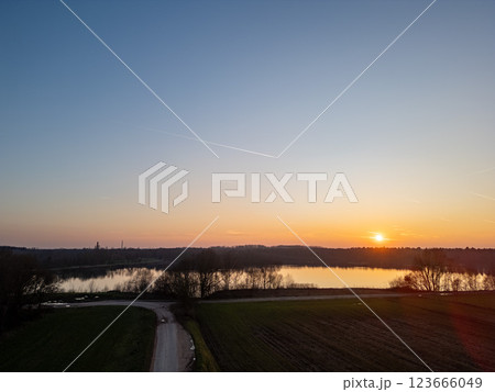 A Serene Sunset Over a Tranquil Lake Surrounded by Breathtaking Natural Landscape 123666049