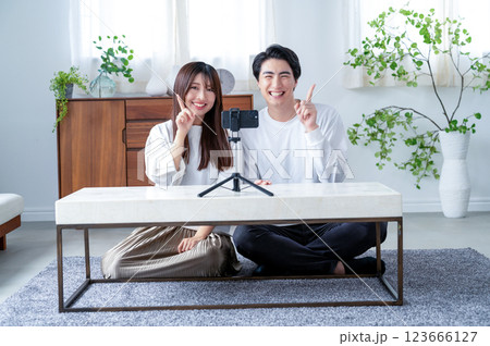 動画撮影で指を立てる男女 動画撮影で指を立てる男女 123666127