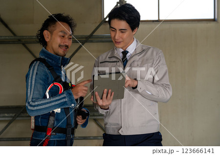 図面を見て打ち合わせをする男性 123666141