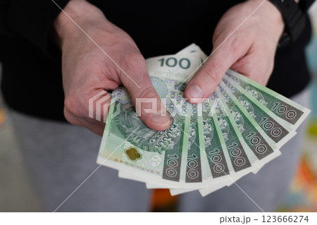 Man holding 100 bills banknotes of Polish zloty. Closeup. Man holding 100 bills banknotes of Polish zloty. Closeup. 123666274