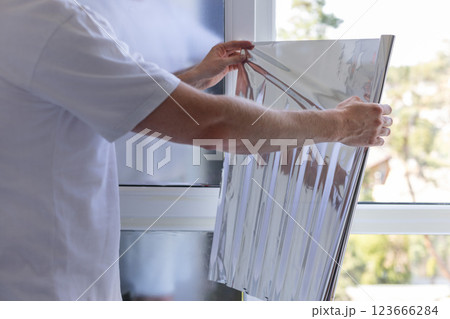 Man holding unrolled windows sun protection film. Man holding unrolled windows sun protection film. 123666284