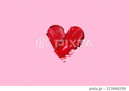 Smearing red heart-shaped lipstick isolated on pink background. Red lipstick glossy texture in heart shape. Cosmetic product swatch Copy space banner photo 123666299