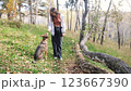 Young woman walking with a dog in an autumn forest 123667390