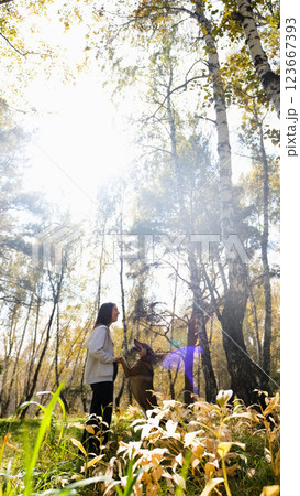 Young woman walking with a dog in an autumn forest Young woman walking with a dog in an autumn forest 123667393