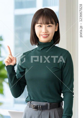 人差し指を立てて案内する笑顔の女性・ビジネスウーマン 人差し指を立てて案内する笑顔の女性・ビジネスウーマン 123667828