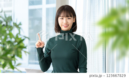 人差し指を立てて案内する笑顔の女性・ビジネスウーマン 人差し指を立てて案内する笑顔の女性・ビジネスウーマン 123667829