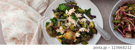 Pasta with baked vegetables and baked white fish sardines, mixed salad with boiled beet and young cabbage and radishes with herbs 123668212