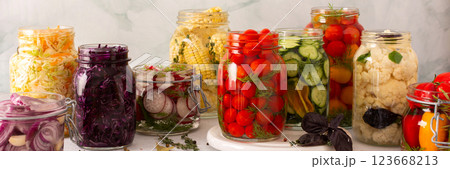Fresh vegetables like cabbage, tomatoes, cucumbers and radishes, onions, corn, peppers and cauliflower, fermenting naturally to boost health and preserve nutrients, banner 123668213