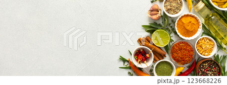 A wide selection of cooking spices and herbs on a gray background, perfect for adding depth to any dish, top view and copy space, banner 123668226
