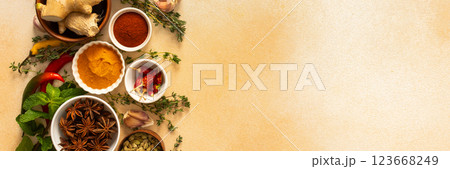 A warm display of spices and herbs on a beige background, each adding rich aromas and flavors, perfect for enhancing recipes, banner 123668249
