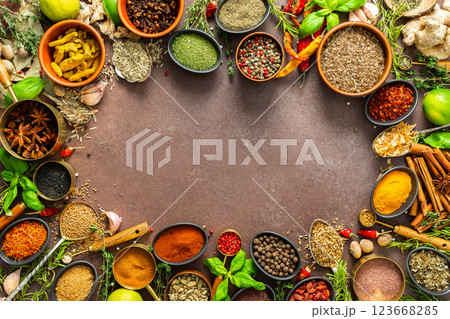 A diverse collection of vibrant spices and herbs, elegantly positioned on a brown backdrop, exuding natural beauty and a burst of fragrances, spice frame 123668285