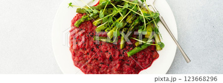 Beetroot risotto with rice and sesame seeds, baked asparagus with microgreens Beetroot risotto with rice and sesame seeds, baked asparagus with microgreens 123668296