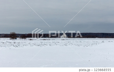Expansive winter field covered in snow with a church in the distance Expansive winter field covered in snow with a church in the distance 123668555
