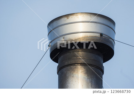 A detailed close up view of a cylindrical metal chimney pipe 123668730