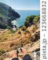 POV Person Sitting on Cliff Edge with Ocean View during Hiking Adventure in Gazipasa Turkey on Sunny 123668832