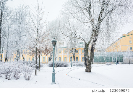 A scenic snow-covered park featuring frosted trees, a classic lamppost 123669073