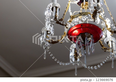 Luxurious chandelier featuring intricate crystal pendants and golden details 123669076