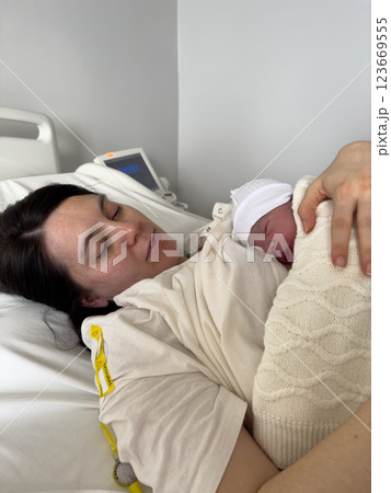 Mother Holding Newborn in Hospital Bed 123669555