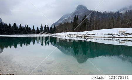 Serene Winter Lake with Mountain Reflections and Benches 123670151