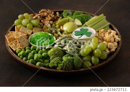St Patricks day charcuterie board, shamrock and party decorations on brown background. Festive holiday appetizer for celebration. Close up. 123672711