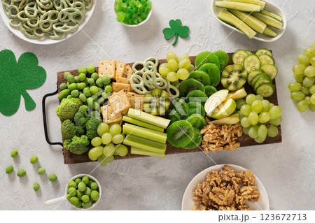St. Patrick's Day Inspired Snacks charcuterie board with fresh vegetables decorated traditional green clover leaves on light background. Festive holiday appetizer. Top view St. Patrick's Day Inspired Snacks charcuterie board with fresh vegetables decorated traditional green clover leaves on light background. Festive holiday appetizer. Top view 123672713